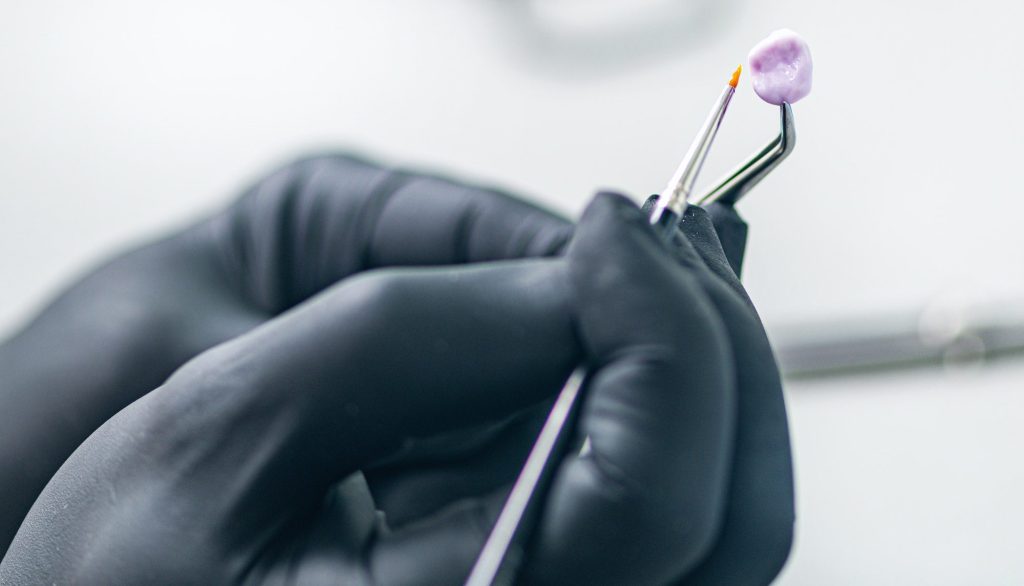 Teeth Prosthetics. Dental Technician Shaping and Polishing Dental Crown.